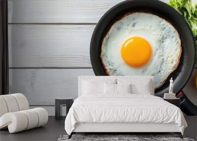 Breakfast table Fried egg in a frying pan on a white wooden surface accompanied by a salad and lemon water. with copy space image. Place for adding text or design Wall mural