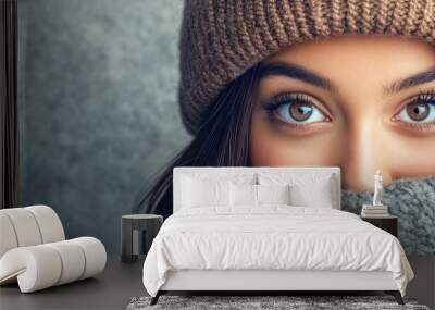 Brunette beautiful Hispanic girl with a winter hat covering one eye and a confident smile on her face expressing a sense of surprise. with copy space image. Place for adding text or design Wall mural