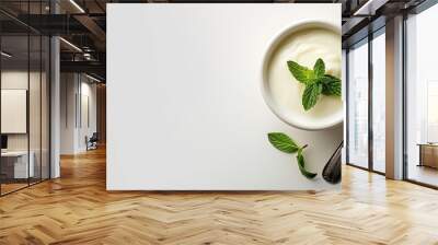 Ceramic bowl with yogurt mint leaf and spoon on white background ideal for health and food concepts offering room for text. with copy space image. Place for adding text or design Wall mural