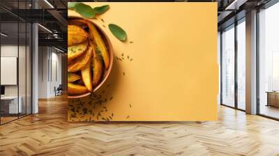 Closeup of crispy deep fried American potato wedges with herbs in a black bowl isolated pastel background Copy space Wall mural