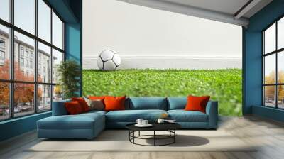 Copy space image with a ball resting on synthetic turf against a clean white backdrop. Wall mural