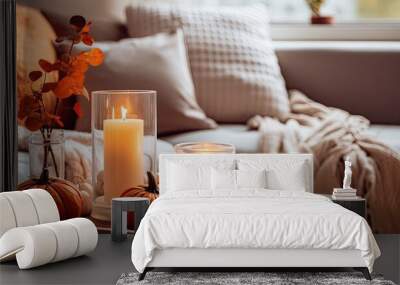 Create a warm autumn ambiance with a hygge home decor setup featuring orange and gray pumpkins and lit candles on a tray placed on a coffee table in the living room, with clear focal point. Include Wall mural