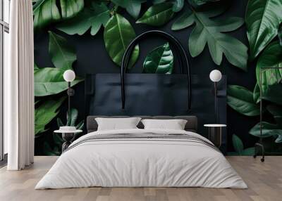 Dark background with green leaves frames a black shopping bag in a mockup offering copy space image Wall mural