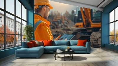 Engineer in a helmet with a digital tablet next to construction excavator. Copy space image. Place for adding text or design Wall mural