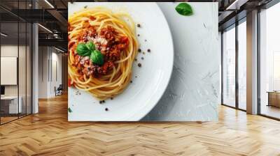 Flat lay of a traditional Italian dish spaghetti bolognese served on a white plate against a clear light backdrop ideal for a copy space image Wall mural