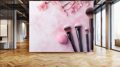 Professional makeup brushes and powder blush balls with pink spring flowers on a light background arranged flat lay top view copy space Beauty product makeup women s accessory fashion Cosmetic makeup Wall mural