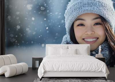 Snowy winter portrait of a woman outdoors on a white winter day A beautiful Asian girl smiling happily outside. with copy space image. Place for adding text or design Wall mural