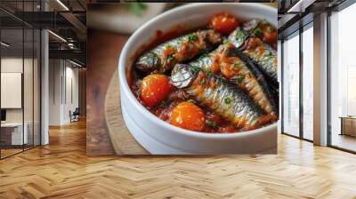 The canned sardine in tomato sauce along with cooking ingredients was beautifully arranged on a white plate with a stainless spoon and fork on a napkin positioned closely on a wooden table copyspace Wall mural