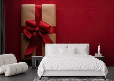 The gift is elegantly presented in a craft paper wrapping, adorned with a festive red ribbon, set against a red background, symbolizing the New Year festivities with a copy space image. Wall mural