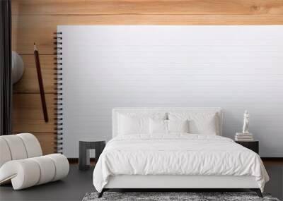 Top view of a wooden office desk with pencils and a blank notebook page in the center for text input, creating a copy space image. Wall mural