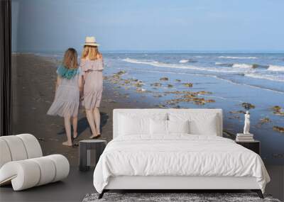 Happy mom and daughter spend time together at the seaside, family concept. Wall mural