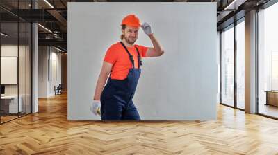 orange hard hat repair master stands against white wall background Wall mural