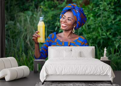 portrait of a beautiful mature african woman with fruit juice, h Wall mural