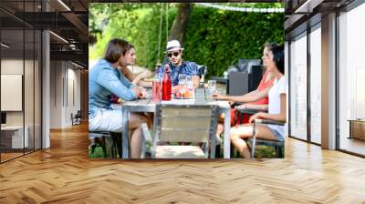 group of friends having fun picnic lunch party outdoor in backyard during summer holiday vacation Wall mural