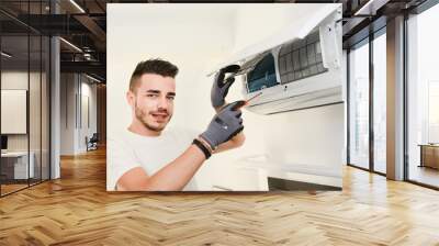 handsome young man electrician installing air conditioning in a client house Wall mural