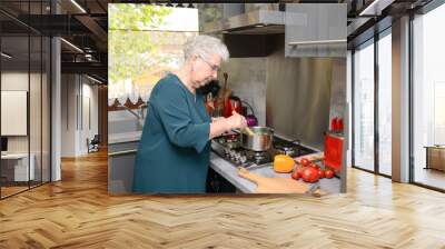 happy senior active woman cooking at home in a modern kitchen Wall mural