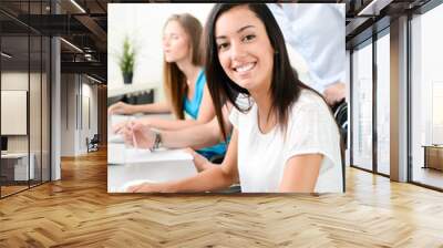 portrait of a young ethnic woman with people in business school office classroom working on a desktop computer with teacher Wall mural