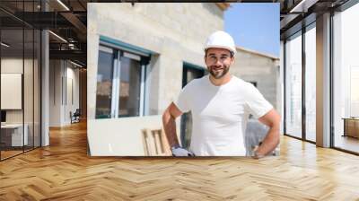 portrait of handsome construction worker on a house building industry construction site Wall mural