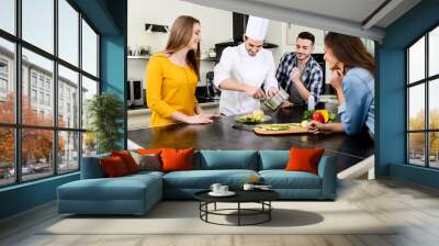 professional personal chef cook in customer's private kitchen house giving a cooking lesson to young Wall mural