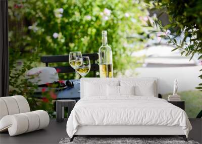 two glass of cool white wine with bottle outdoor in restaurant terrace during a sunny summer day Wall mural