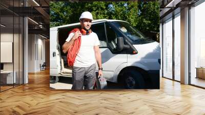 young electrician artisan taking tools out of his professional truck van Wall mural