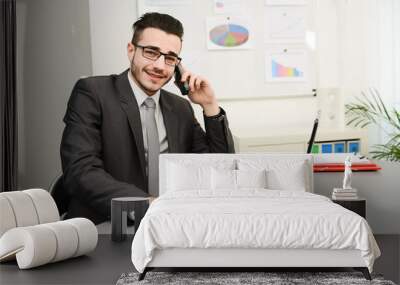 young man in office working with laptop computer and phone Wall mural