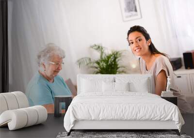 young woman helping old person for paperwork and telephone call Wall mural