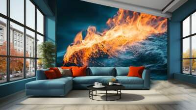 Captivating image of flames emerging from water, showcasing the contrast between fire and liquid elements in nature. Wall mural