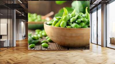 Fresh steamed edamame in a wooden bowl on a rustic table, sprinkled with sea salt. Healthy vegan snack, ready to eat. Wall mural