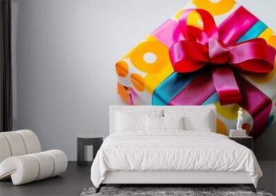 A colorful gift box wrapped in vibrant ribbons and elegant patterns, arranged on a clean white surface, symbolizing celebrations, surprises, and joyful occasions  Wall mural