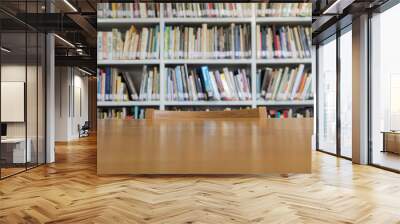 Wooden table with bookshelves in library Wall mural