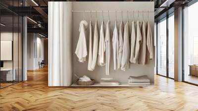 A minimalist clothing rack holding neatly arranged neutral-toned garments in an airy, well-lit room. The simple layout emphasises clean lines, natural fabrics and a fresh, organised atmosphere. Wall mural