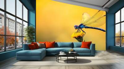  A blue dragonfly perches above a yellow bloom against a backdrop of yellow and green Foreground features a solitary yellow flower Wall mural