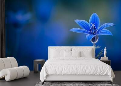  A blue flower in sharp focus on its stem against a softly blurred background of blue sky and hazy greenery Wall mural