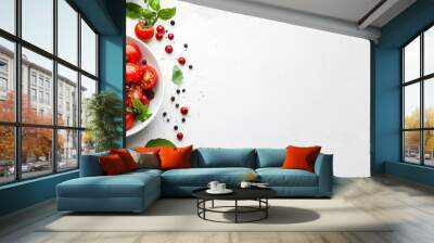  A white bowl brimming with varied tomato types and a bed of spinach atop a pristine countertop Wall mural