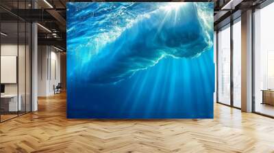   An underwater perspective of a blue ocean with sunlight penetrating the top of a large shark's open maw Wall mural