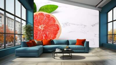  Two grapefruits atop a white counter, beside a verdant leafy plant Wall mural