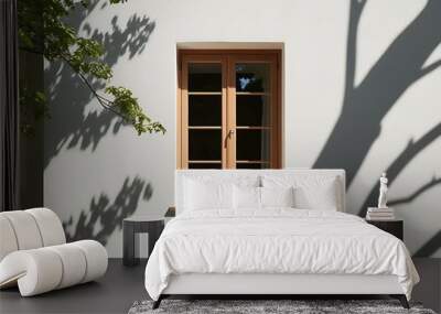 Shadow of tree branch on window and wall with sunlight filtering through wood, highlighting the architecture and glass frame of the house in a minimalist design featuring nature and light (6) Wall mural