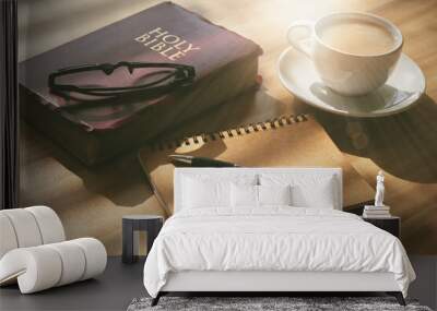 Pray and study the Bible in the morning in the warm sunshine on a bright day. with a cup of coffee and a notebook Placed on a wooden table under the bright morning sun. Wall mural