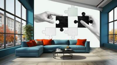 Two hands assembling a puzzle with black and white pieces, symbolizing collaboration and problem-solving. Wall mural