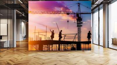 Two men in construction gear are pointing at a building. The sun is setting in the background. Scene is serious and focused Wall mural