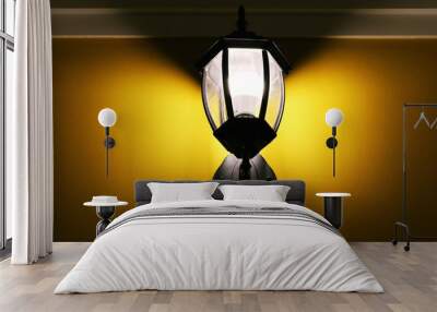 Electric lighting lamp on yellow wall closeup interior Wall mural