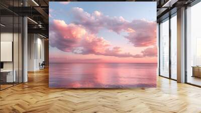 Cirrus clouds tinted pink by the sun at sunset over a calm blue ocean Wall mural