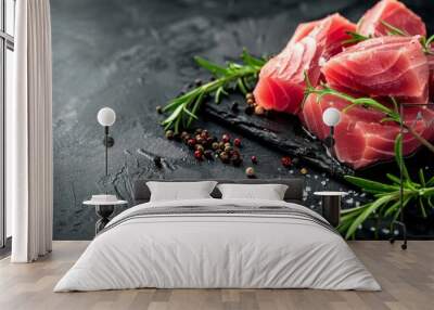 Sliced raw tuna fillet on a dark background with rosemary and pepper Wall mural