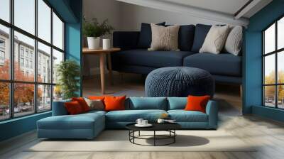 Two knitted poufs near dark blue corner sofa. Scandinavian home.generative.ai Wall mural