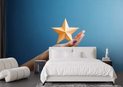 Woman's hand holds one star on a blue background. Wall mural