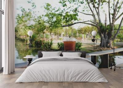 plastic cup of iced americano (black coffee) in the garden background Wall mural