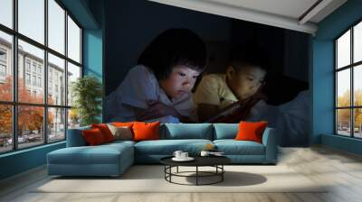 two chinese children addicted tablet, asian child watching telephone together on their bed, kid using smartphone
 Wall mural