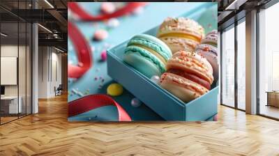 Close up of beautifully arranged colorful French macarons displayed in a gift box with decorative red ribbon  The macarons feature various pastel shades and flavors Wall mural