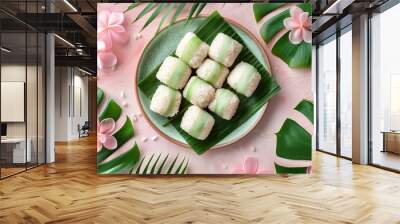 Closeup view of a delicious tropical coconut dessert served on green leaves with pink floral accents creating a minimalist and natural still life composition Wall mural